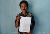 Foto: Sanip warga Dusun Gelumpang, Desa Labuhan Haji menunjukkan bukti laporan polisi atas dugaan penipuan. 